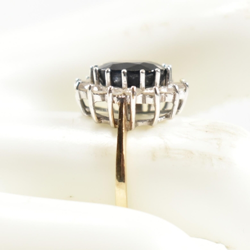 318 - A hallmarked 9ct gold, sapphire and CZ ring. The ring having a central oval cut sapphire surrounded ... 