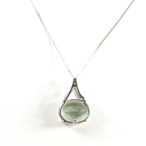 320 - A hallmarked 9ct white gold, diamond and green stone pendant necklace. The pendant set with an oval ... 