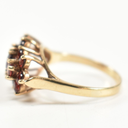 322 - A hallmarked 9ct gold and garnet cluster ring. The ring set with three central graduating round cut ... 