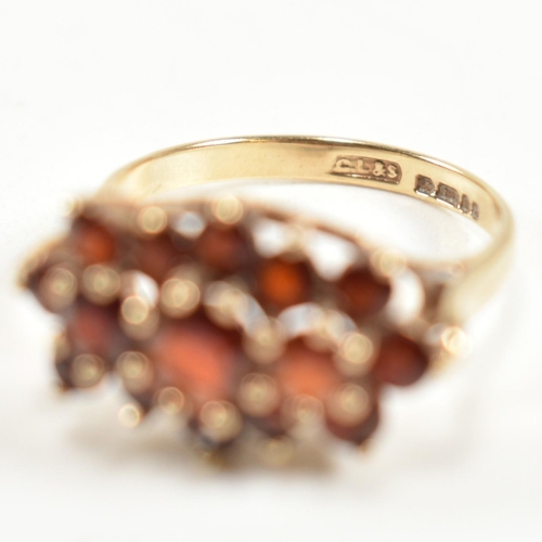 322 - A hallmarked 9ct gold and garnet cluster ring. The ring set with three central graduating round cut ... 