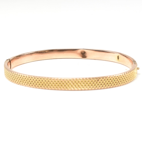 324 - A vintage hallmarked 9ct gold hinged bangle. The bangle having a textured pineapple decoration to he... 