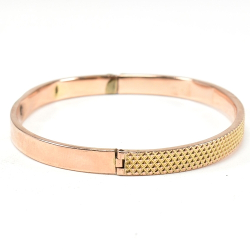 324 - A vintage hallmarked 9ct gold hinged bangle. The bangle having a textured pineapple decoration to he... 