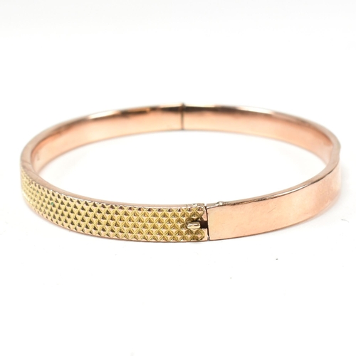 324 - A vintage hallmarked 9ct gold hinged bangle. The bangle having a textured pineapple decoration to he... 