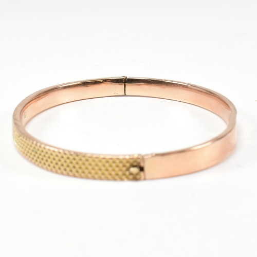 324 - A vintage hallmarked 9ct gold hinged bangle. The bangle having a textured pineapple decoration to he... 