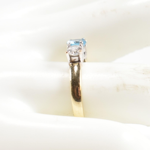 328 - A hallmarked 9ct gold, CZ and topaz three stone ring. The ring having a central four claw set round ... 