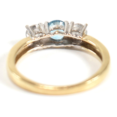 328 - A hallmarked 9ct gold, CZ and topaz three stone ring. The ring having a central four claw set round ... 