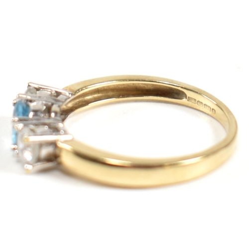 328 - A hallmarked 9ct gold, CZ and topaz three stone ring. The ring having a central four claw set round ... 