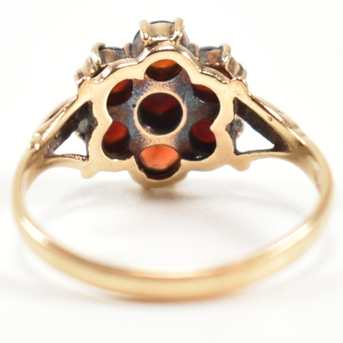 332 - A hallmarked 9ct gold and garnet cluster ring. The ring having central six claw set round cut garnet... 