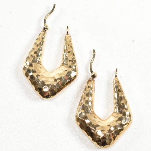 335 - A pair of hallmarked 9ct gold hammered hoop earrings. The arrow-shape hoop earrings having an all-ov... 