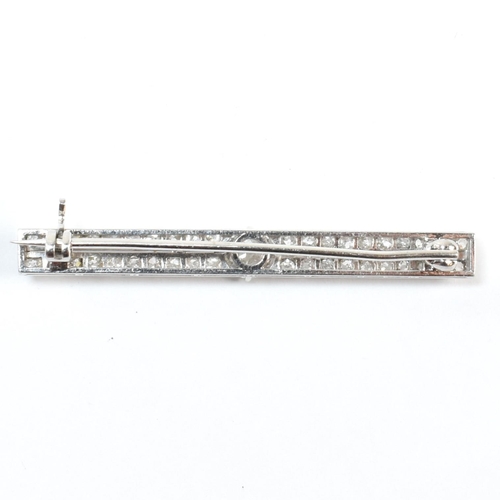 34 - An Edwardian platinum and diamond bar brooch pin. The brooch set with a central old cut diamond flan... 