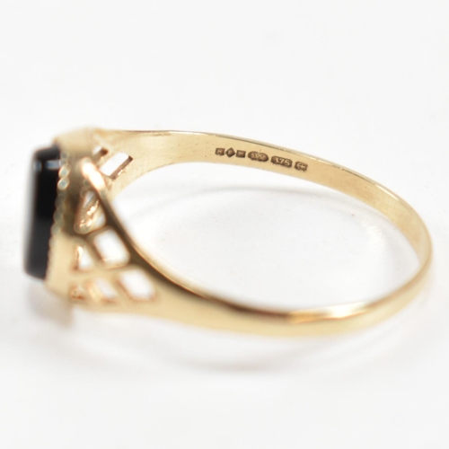 343 - A hallmarked 9ct gold and black stone signet ring. The ring set with a bezel set oval cut black ston... 