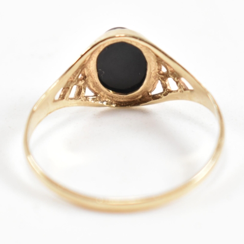 343 - A hallmarked 9ct gold and black stone signet ring. The ring set with a bezel set oval cut black ston... 