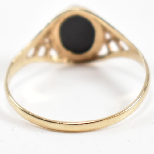 343 - A hallmarked 9ct gold and black stone signet ring. The ring set with a bezel set oval cut black ston... 