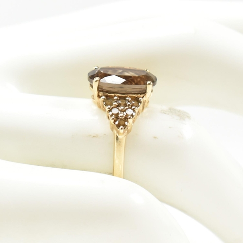 344 - A hallmarked 9ct gold and smoky quartz ring. The ring having a central four claw set oval cut smoky ... 