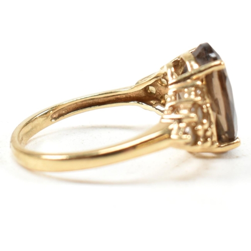 344 - A hallmarked 9ct gold and smoky quartz ring. The ring having a central four claw set oval cut smoky ... 