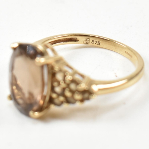 344 - A hallmarked 9ct gold and smoky quartz ring. The ring having a central four claw set oval cut smoky ... 