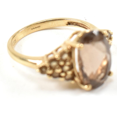 344 - A hallmarked 9ct gold and smoky quartz ring. The ring having a central four claw set oval cut smoky ... 