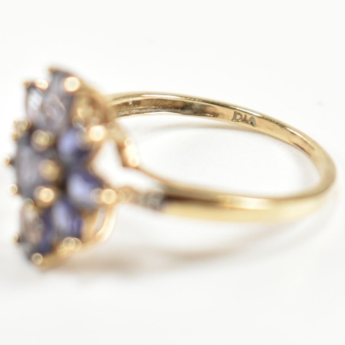 354 - A hallmarked 9ct gold and iolite cluster ring. The ring having a central eight claw set round cut io... 