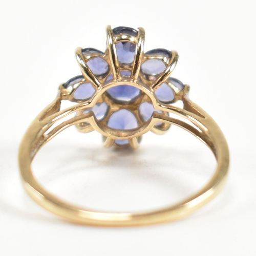 354 - A hallmarked 9ct gold and iolite cluster ring. The ring having a central eight claw set round cut io... 