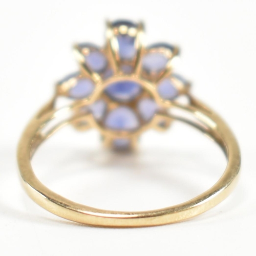 354 - A hallmarked 9ct gold and iolite cluster ring. The ring having a central eight claw set round cut io... 