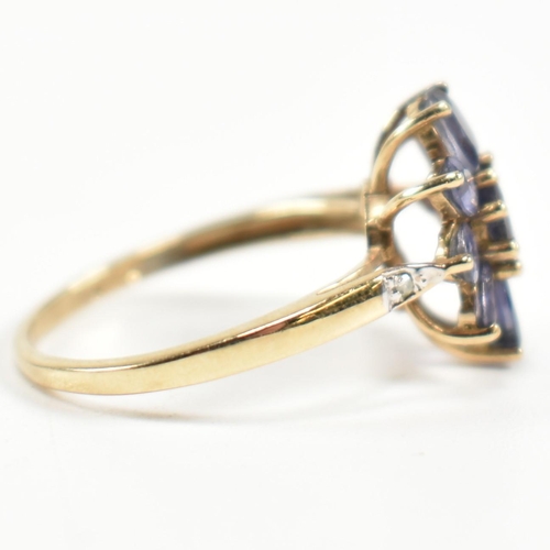 354 - A hallmarked 9ct gold and iolite cluster ring. The ring having a central eight claw set round cut io... 