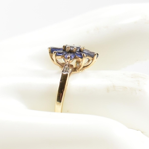 354 - A hallmarked 9ct gold and iolite cluster ring. The ring having a central eight claw set round cut io... 