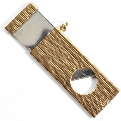 38 - A hallmarked 9ct gold cigar cutter. The cigar cutter having a textured body. Hallmarked for London, ... 