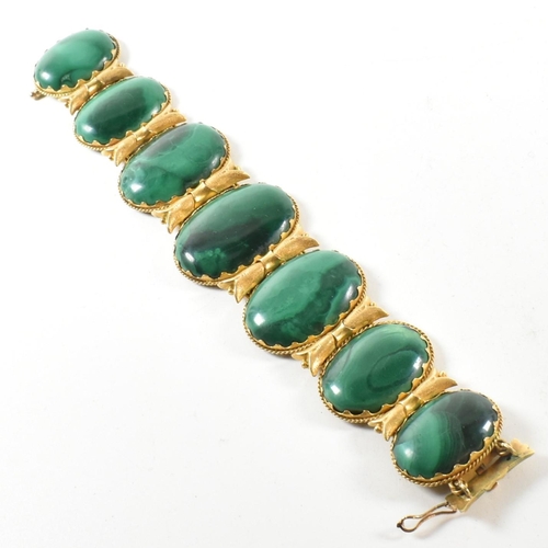 4 - A 19th century gold and malachite panel bracelet. The bracelet mounted with seven oval malachite pan... 