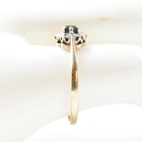 405 - A hallmarked 9ct gold, sapphire and diamond cluster ring. The ring having a central six claw set rou... 