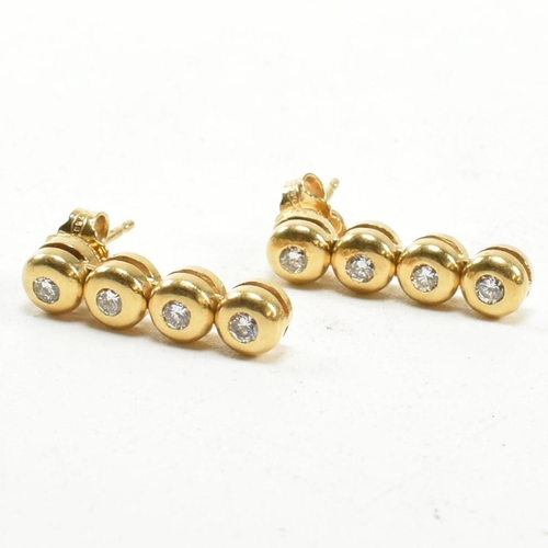 406 - A pair of hallmarked 18ct gold and diamond pendant earrings. The earrings having four bezel set roun... 