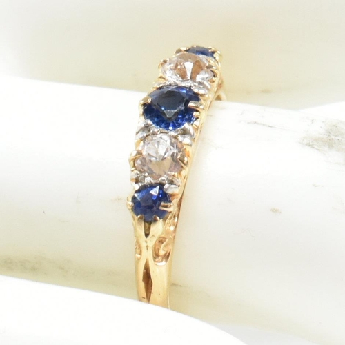 49 - An 18ct gold and sapphire five stone gypsy ring. The ring set with blue and white sapphire to a scro... 