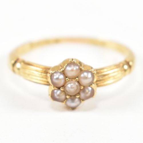 63 - A Victorian hallmarked 18ct gold and seed pearl cluster ring. The ring having a cluster of seven rou... 