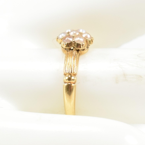 63 - A Victorian hallmarked 18ct gold and seed pearl cluster ring. The ring having a cluster of seven rou... 