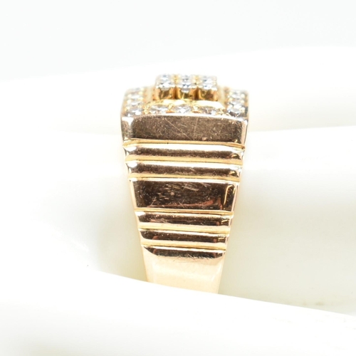 66 - A hallmarked 18ct gold and diamond signet ring. The ring having a square face set with nine round cu... 