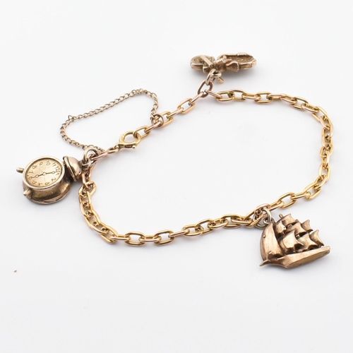 70 - A hallmarked 9ct gold charm bracelet. The bracelet strung with three yellow metal charms including a... 