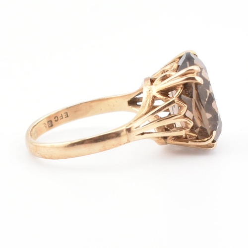 74 - A 9ct gold and smoky quartz cocktail ring. The ring set with a claw mounted smoky quartz in a pierce... 