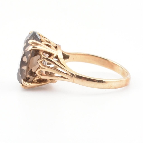 74 - A 9ct gold and smoky quartz cocktail ring. The ring set with a claw mounted smoky quartz in a pierce... 