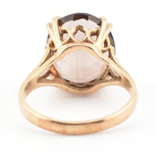 74 - A 9ct gold and smoky quartz cocktail ring. The ring set with a claw mounted smoky quartz in a pierce... 