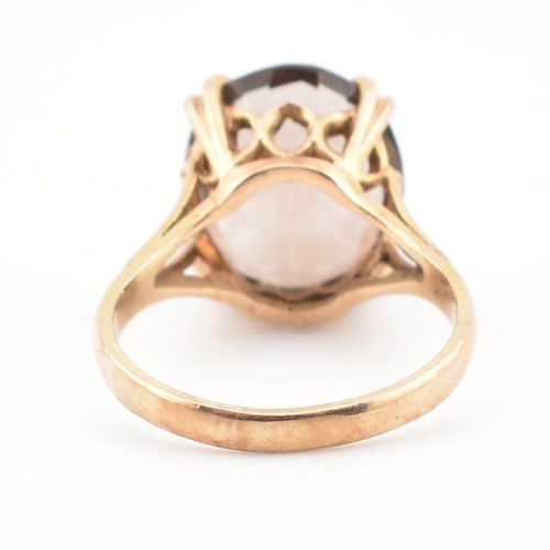 74 - A 9ct gold and smoky quartz cocktail ring. The ring set with a claw mounted smoky quartz in a pierce... 