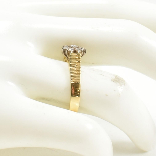 80 - An 18ct gold and diamond cluster ring. The ring set with eight round brilliant cut diamonds with bar... 