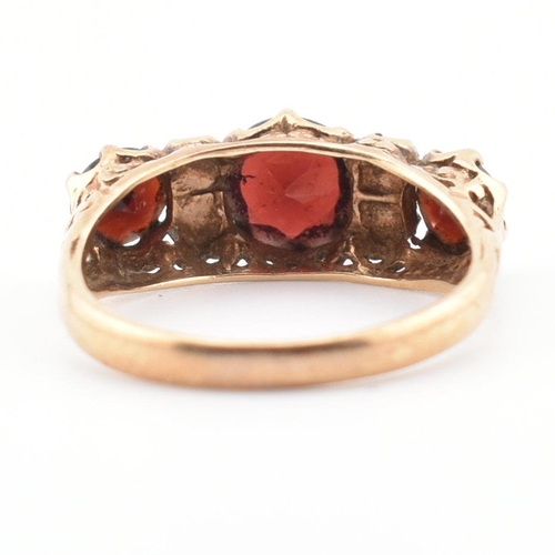 83 - A hallmarked 9ct gold, garnet and pearl three stone ring. The ring having three round mixed cut garn... 