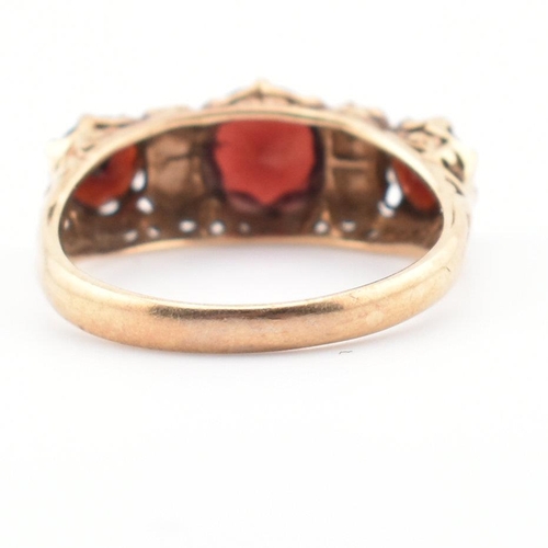 83 - A hallmarked 9ct gold, garnet and pearl three stone ring. The ring having three round mixed cut garn... 