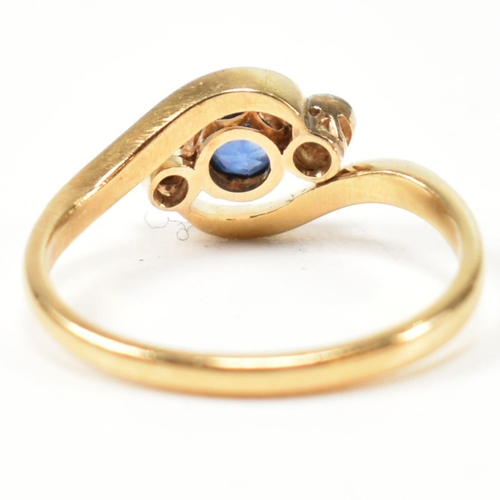 95 - An 18ct gold, diamond and sapphire crossover ring. The ring having a central bezel set round cut dia... 