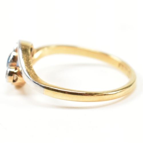 95 - An 18ct gold, diamond and sapphire crossover ring. The ring having a central bezel set round cut dia... 