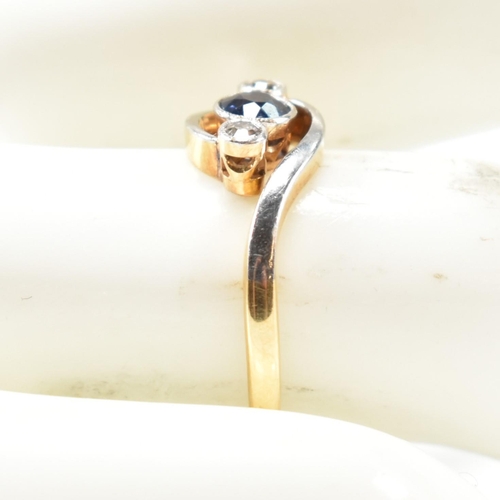 95 - An 18ct gold, diamond and sapphire crossover ring. The ring having a central bezel set round cut dia... 