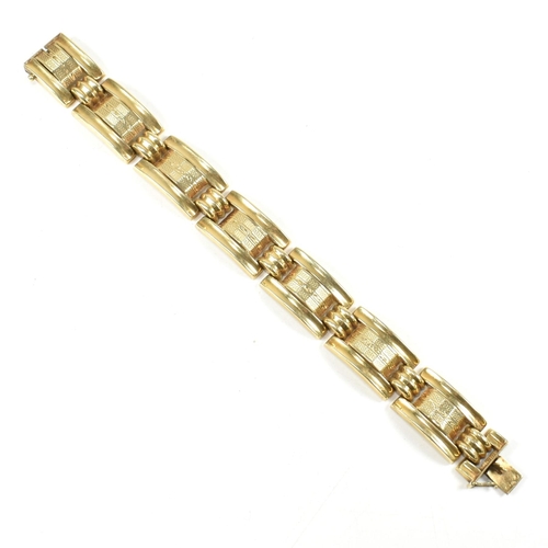 31 - A 14ct gold yellow gold bracelet. The bracelet formed with rectangular tank style links with etched ... 