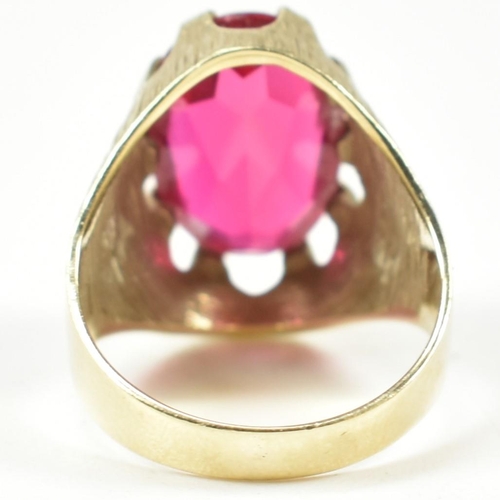 40A - A 1970s 14ct gold and synthetic ruby ring. The ring having a large claw mounted oval mixed cut synth... 