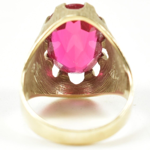 40A - A 1970s 14ct gold and synthetic ruby ring. The ring having a large claw mounted oval mixed cut synth... 