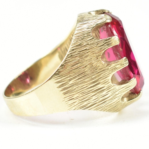 40A - A 1970s 14ct gold and synthetic ruby ring. The ring having a large claw mounted oval mixed cut synth... 