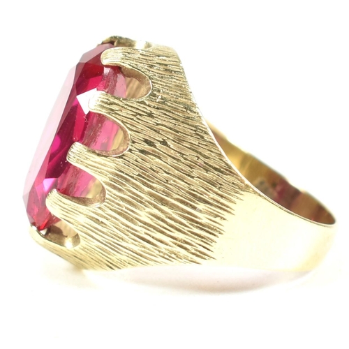 40A - A 1970s 14ct gold and synthetic ruby ring. The ring having a large claw mounted oval mixed cut synth... 